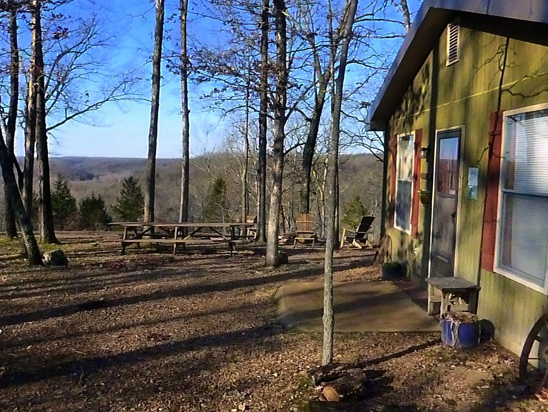 The cottage peers into the valley from the trees.